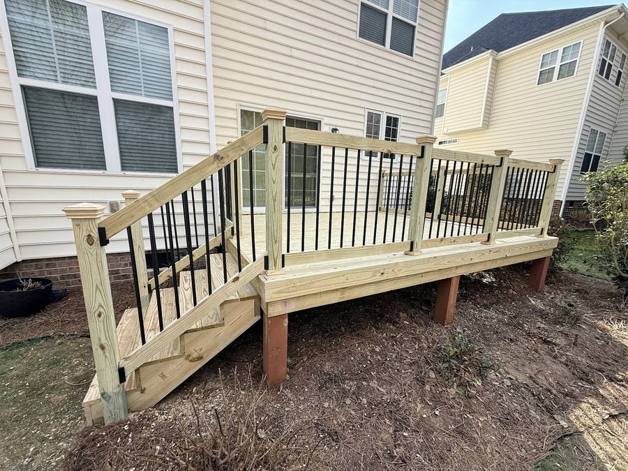 New pressure-treated wood deck with stairs and black aluminum balusters